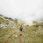 A person carrying a bag hiking.